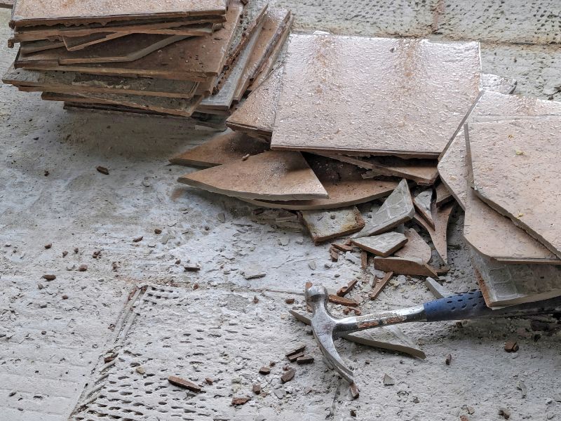 Worker removing old bathroom flooring in Conroe, TX.