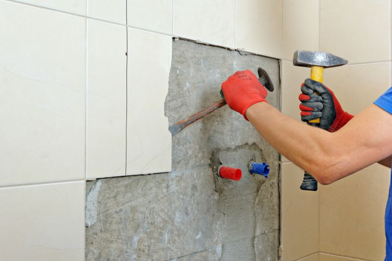 Worker cleaning and removing grout from existing tiles.